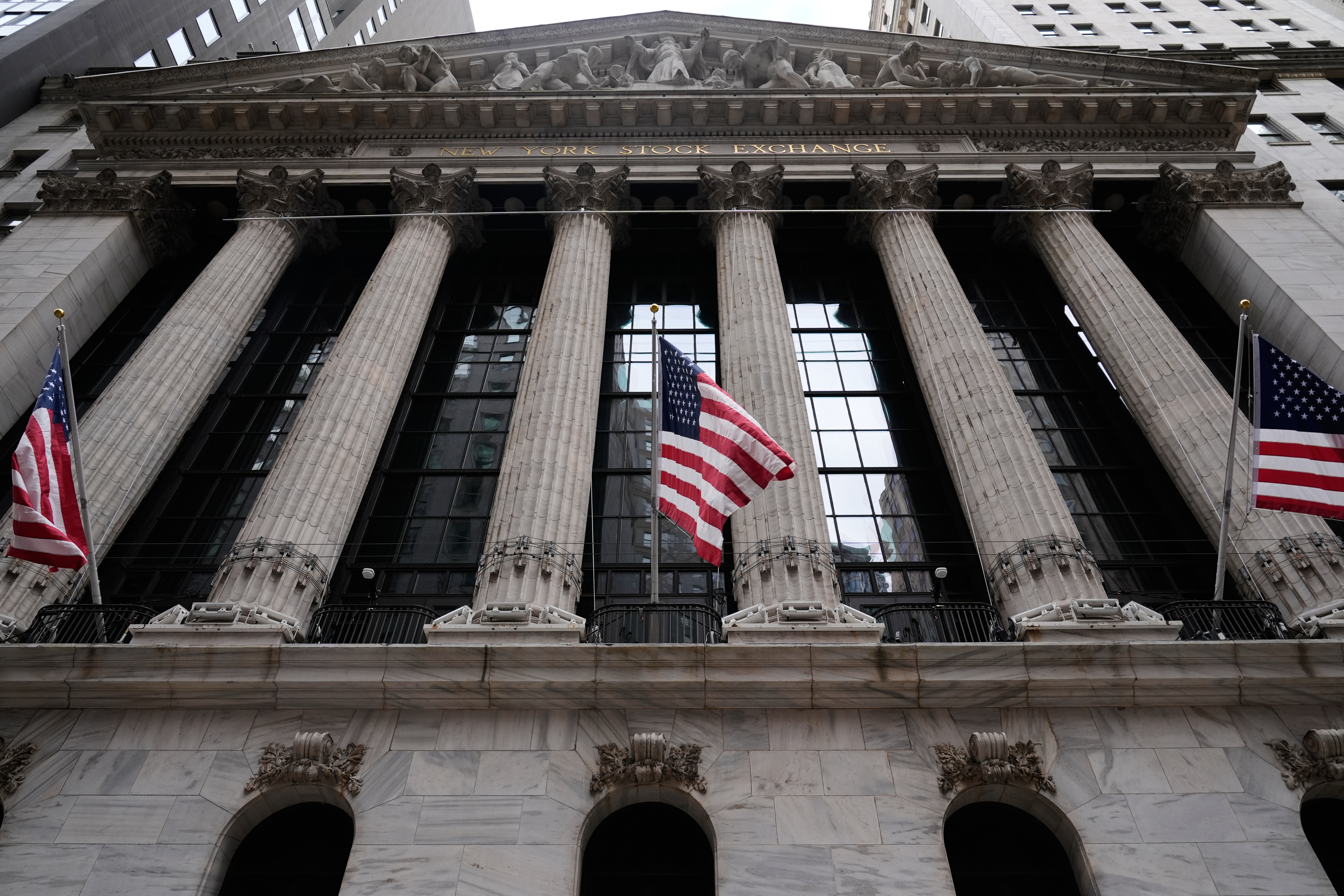 New York Stock Exchange building facade with classical columns and American flags
