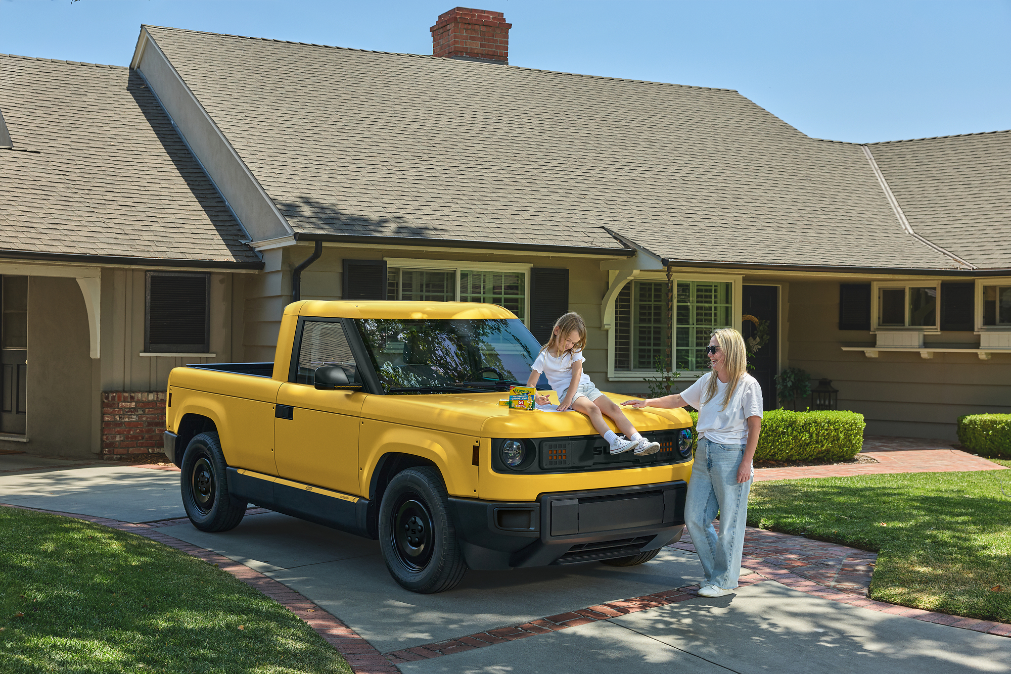 Woman and child with yellow compact truck in residential driveway on sunny day