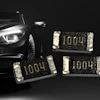 Luxury vehicle headlight with surface-mount resistor components marked 1004 displayed against dark background