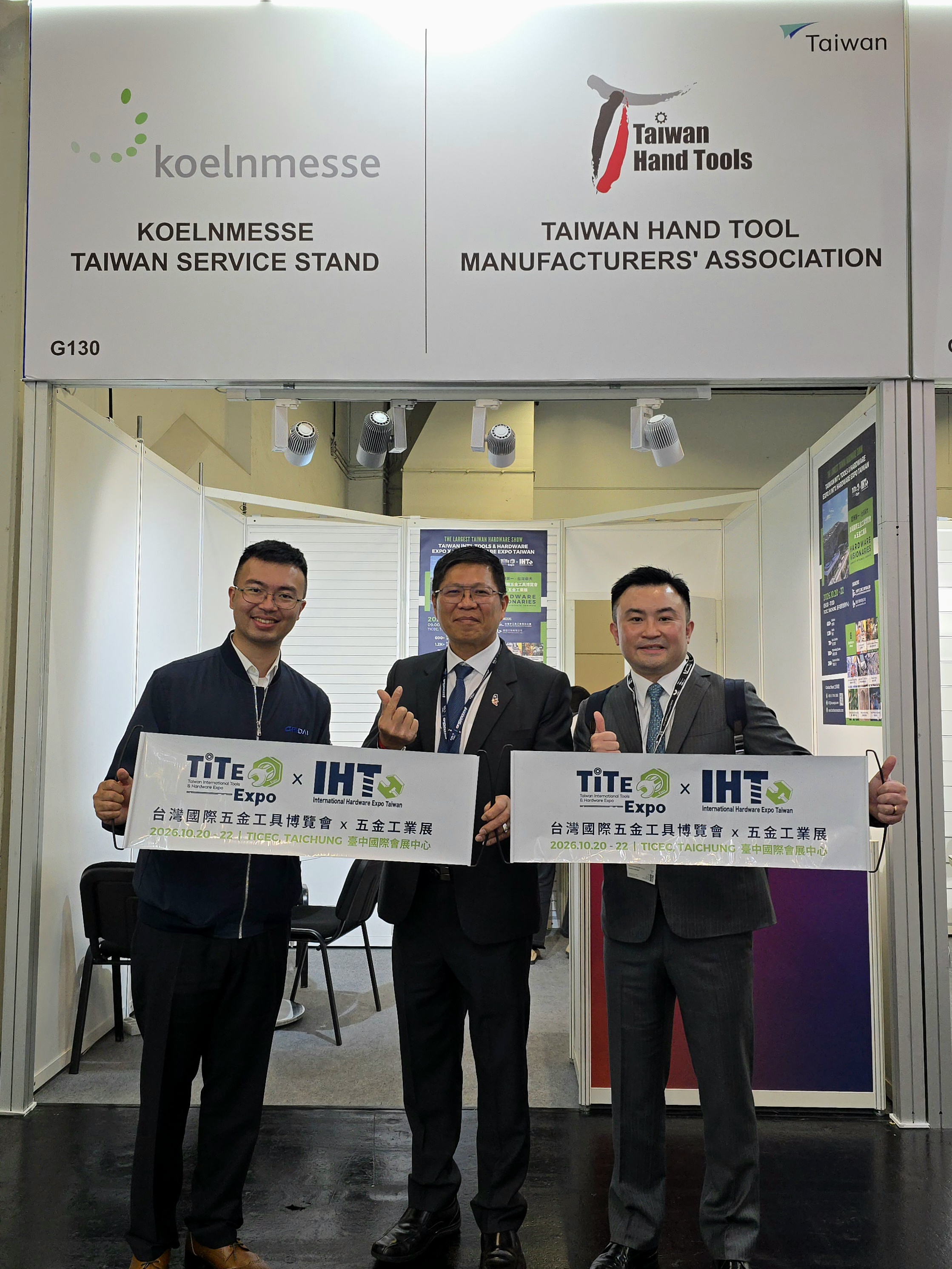 Three professionals at Taiwan Hand Tools booth at Koelnmesse trade show holding TiTE Expo banner