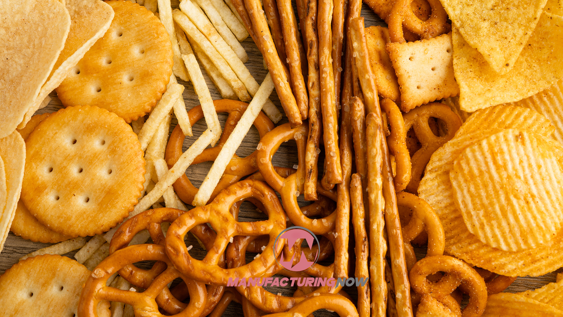 Assorted salty snacks including crackers, pretzels, chips, and breadsticks arranged on wooden surface