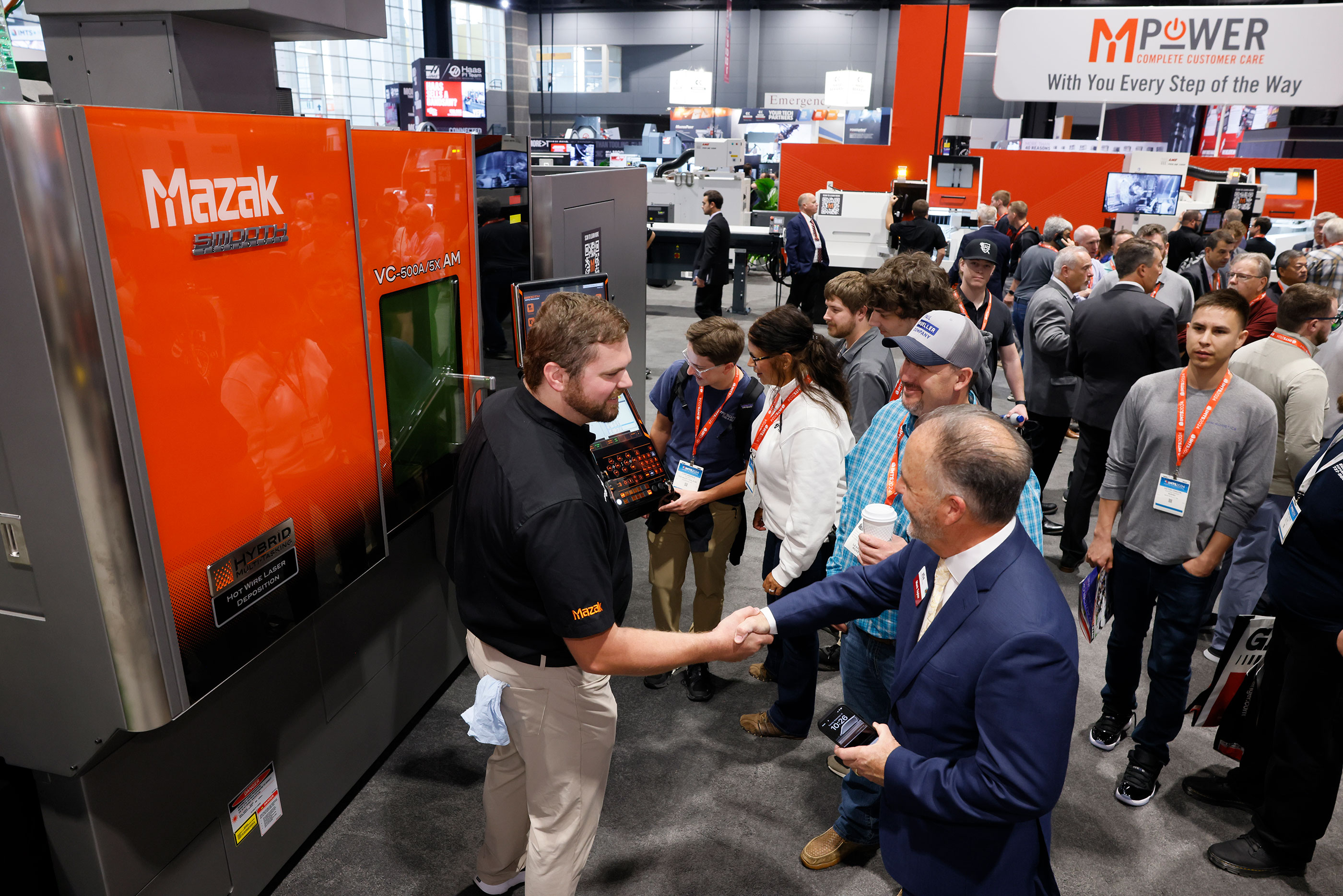 Mazak industrial machinery exhibition with visitors and staff at trade show booth