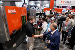 Mazak industrial machinery exhibition with visitors and staff at trade show booth