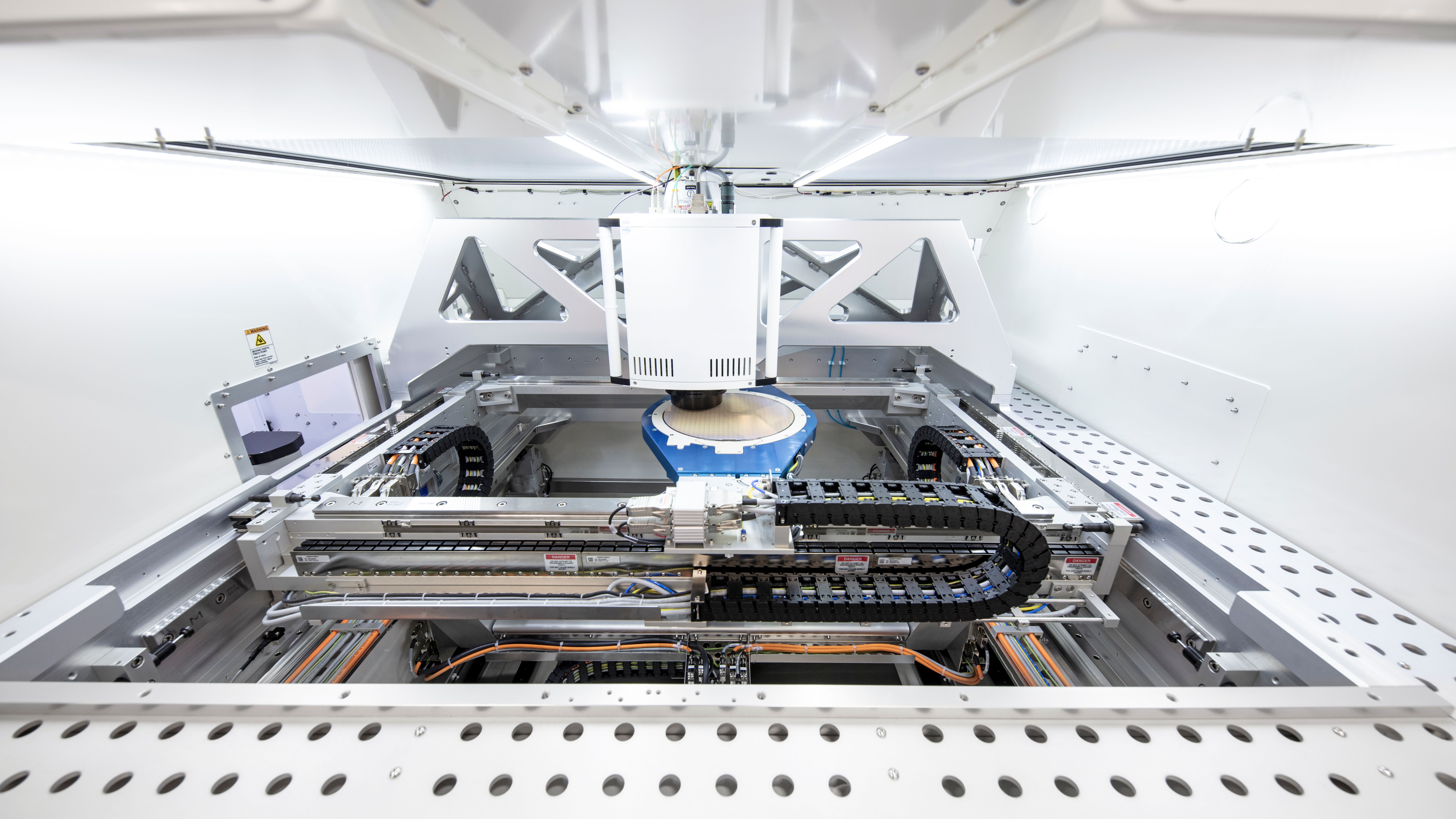 Interior view of automated laboratory analyzer with mechanical components, tracks, and robotic arm system