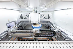 Interior view of automated laboratory analyzer with mechanical components, tracks, and robotic arm system