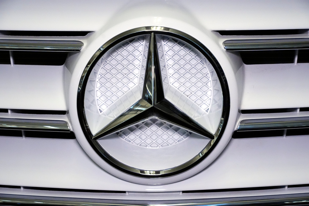 Mercedes-Benz three-pointed star logo on white vehicle grille