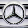 Mercedes-Benz three-pointed star logo on white vehicle grille