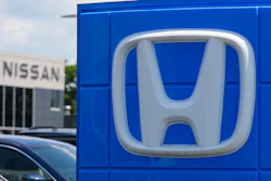 Honda dealership storefront with silver H-logo on blue signage panel