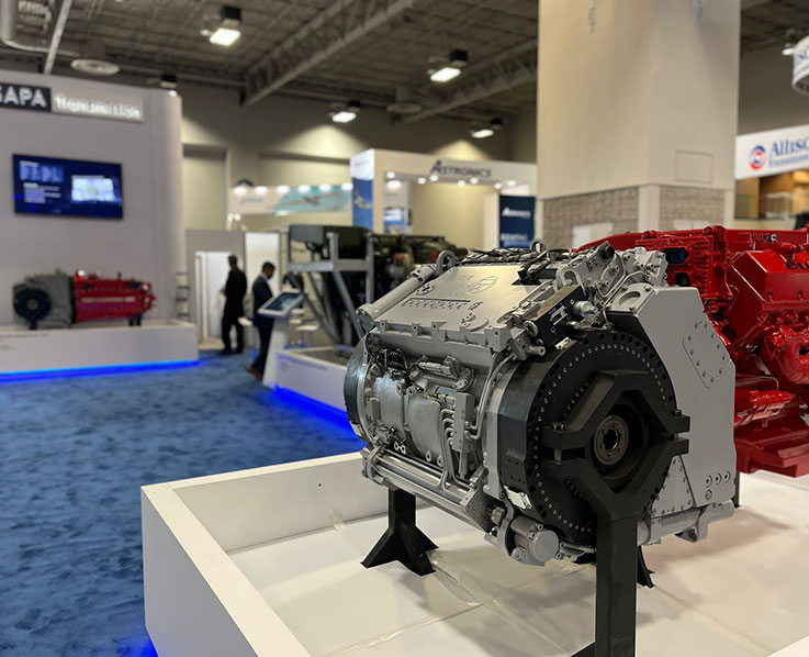 Automotive transmission engine component displayed at trade show booth with NAPA signage visible