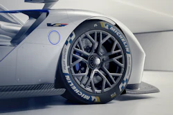 White race car with blue accents displaying Michelin performance tire in detailed side view