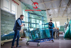 Manufacturing Now logo displayed above workers handling glass panels in industrial warehouse facility