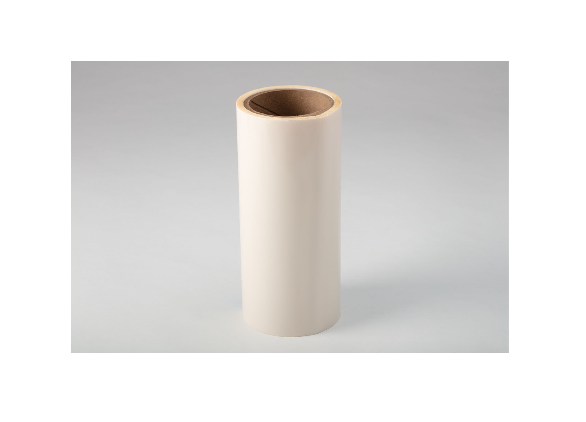 Empty cream-colored cylindrical cardboard tube with brown interior on neutral background