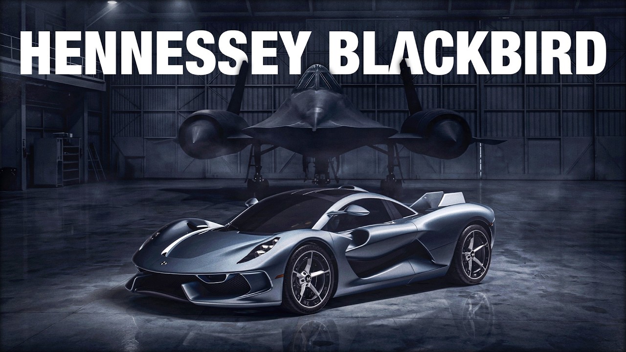 Hennessey Blackbird silver sports car displayed in industrial hangar with aircraft backdrop