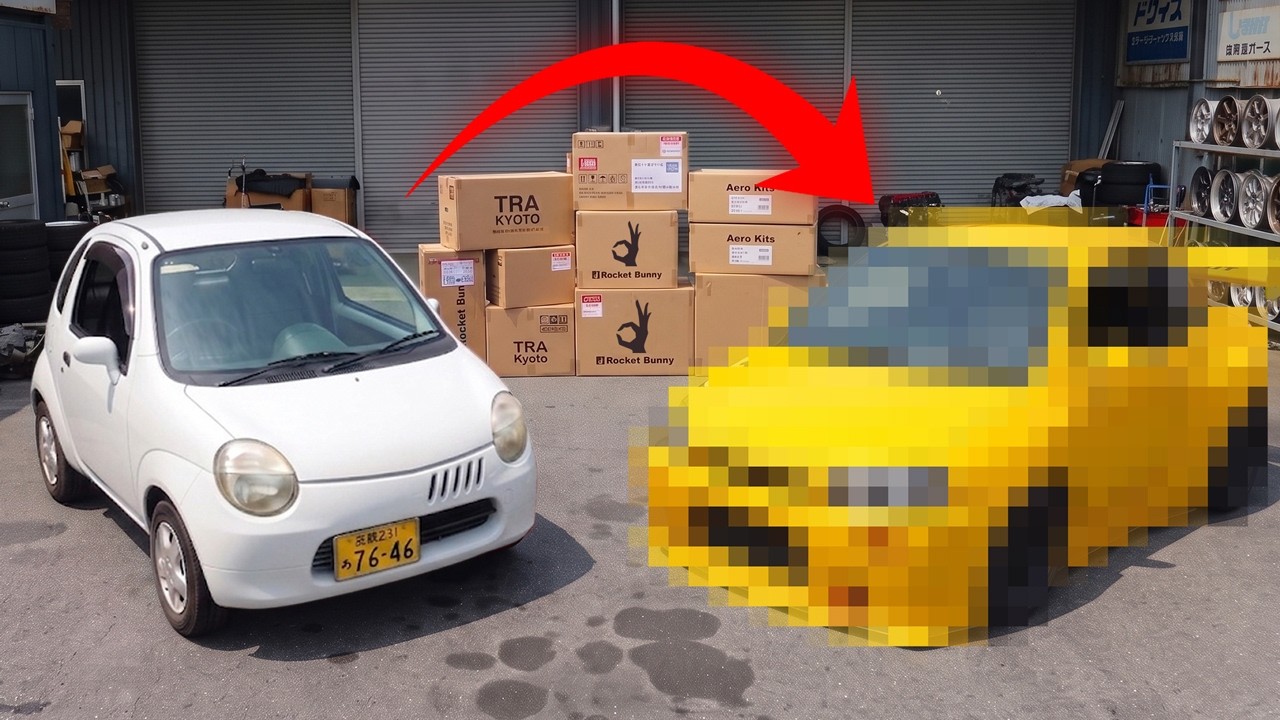 White compact car parked next to stacked cardboard boxes and a pixelated yellow vehicle in an industrial warehouse setting