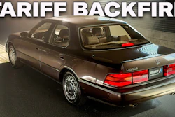 Brown Lexus LS sedan photographed in showroom with red taillights and chrome trim