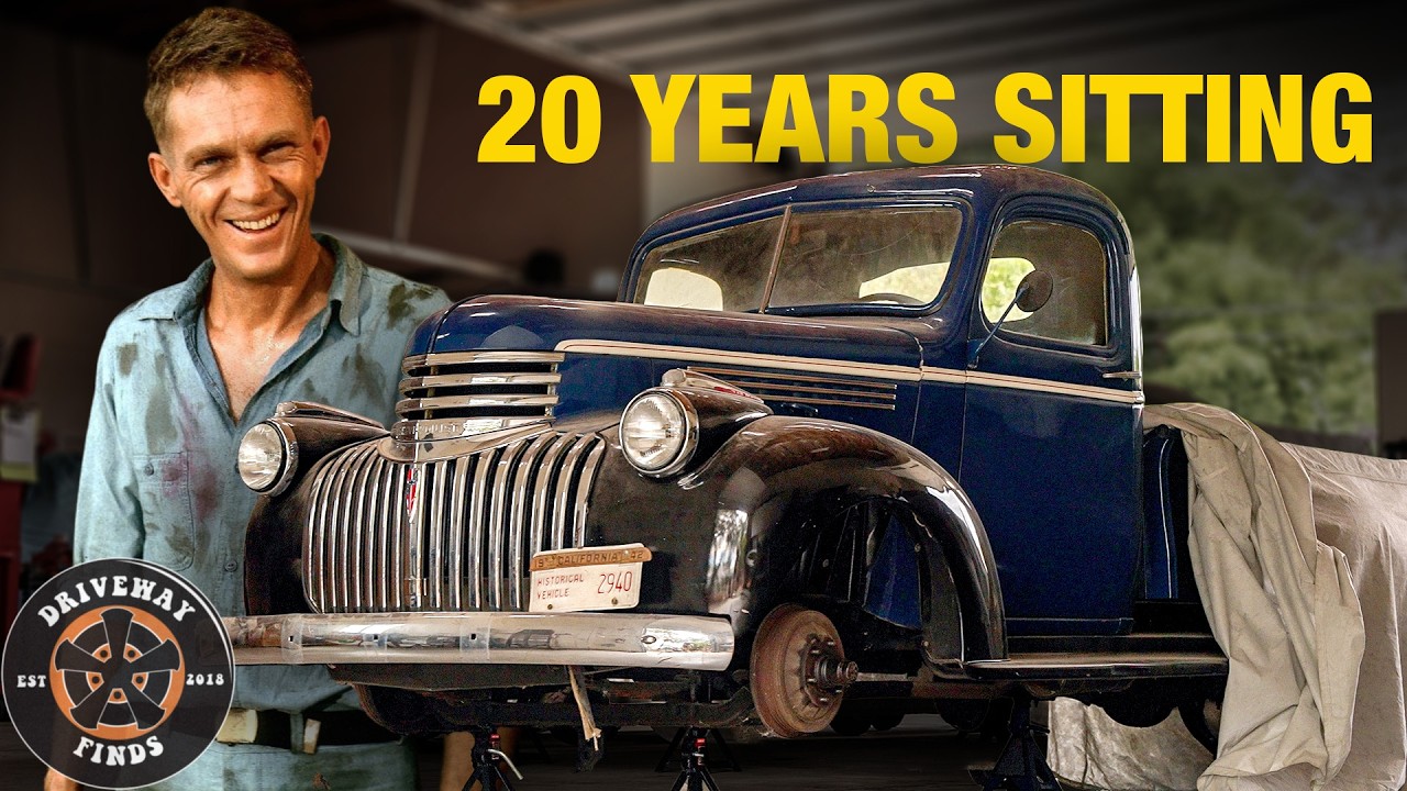 Man smiling next to restored 1940s blue Chevrolet truck with 'Driveway Finds' logo