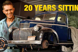 Man smiling next to restored 1940s blue Chevrolet truck with 'Driveway Finds' logo
