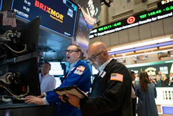 Traders monitor stock market data on the NYSE trading floor with BRIXMOR ticker visible on overhead displays