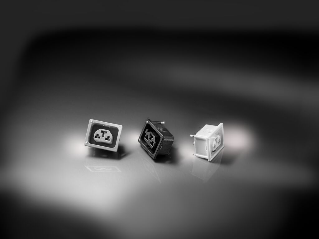 Three mechanical keyboard switches in black, white, and translucent variants displayed on a neutral surface with studio lighting