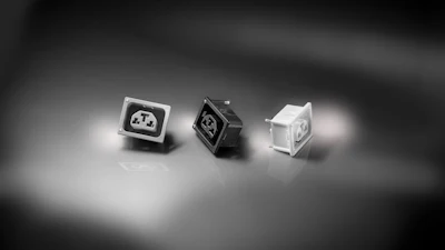 Three mechanical keyboard switches in black, white, and translucent variants displayed on a neutral surface with studio lighting
