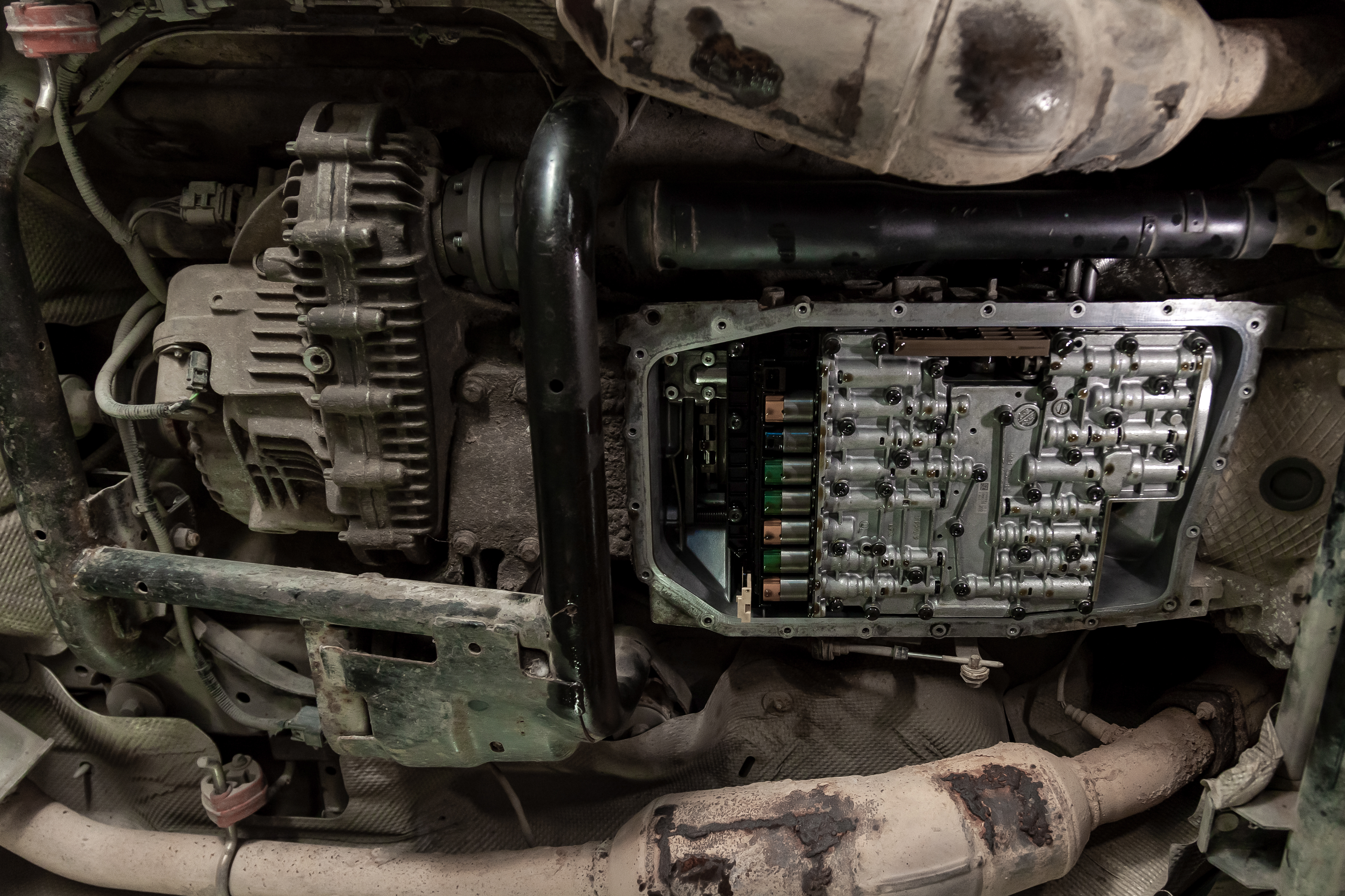 Engine compartment showing alternator, ECU module, and wiring harness in a vehicle