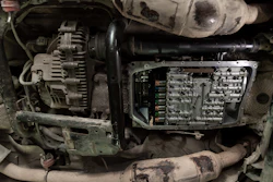 Engine compartment showing alternator, ECU module, and wiring harness in a vehicle