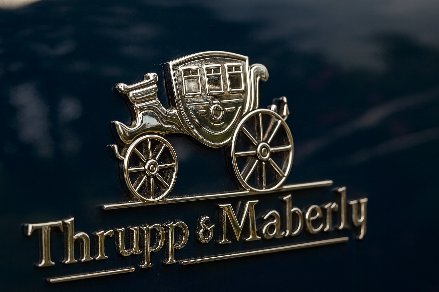 Thrupp & Maberly brass carriage emblem on dark surface