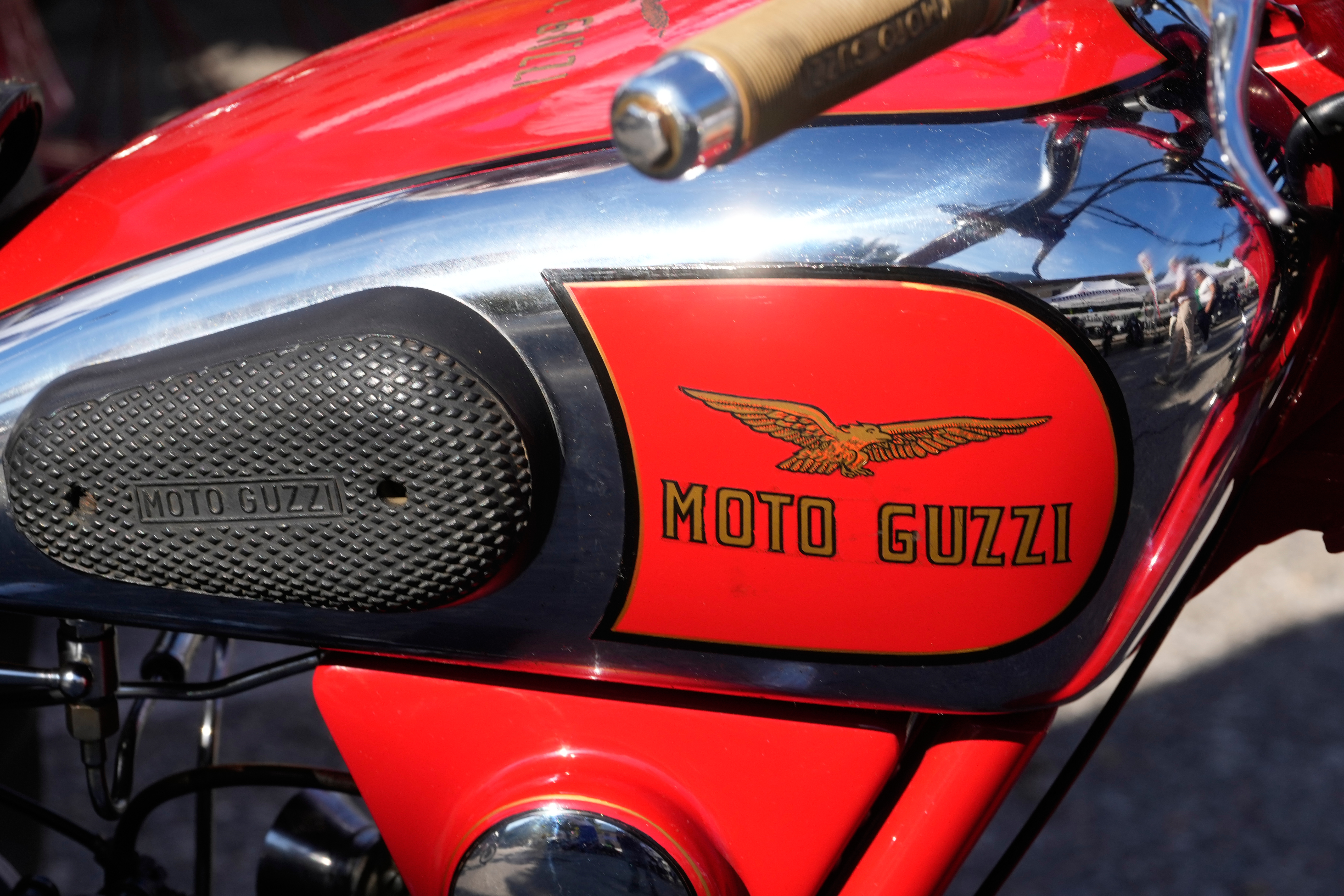 Vintage red Moto Guzzi motorcycle with winged logo on fuel tank and black mesh side panel
