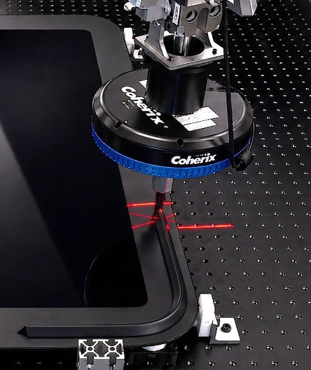 Coherix precision optical equipment with blue collar and red laser alignment marks on optical table