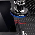 Coherix precision optical equipment with blue collar and red laser alignment marks on optical table
