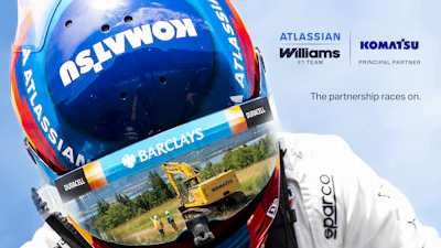 Racing helmet with Atlassian and Williams F1 Team branding, featuring Komatsu partnership announcement and multiple sponsor logos