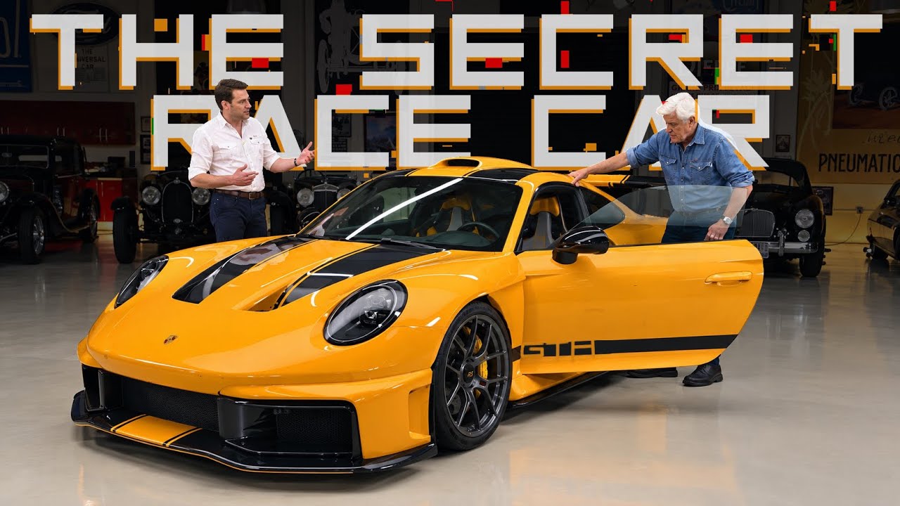 Yellow Porsche 911 GT3 sports car displayed in showroom with two men examining the vehicle