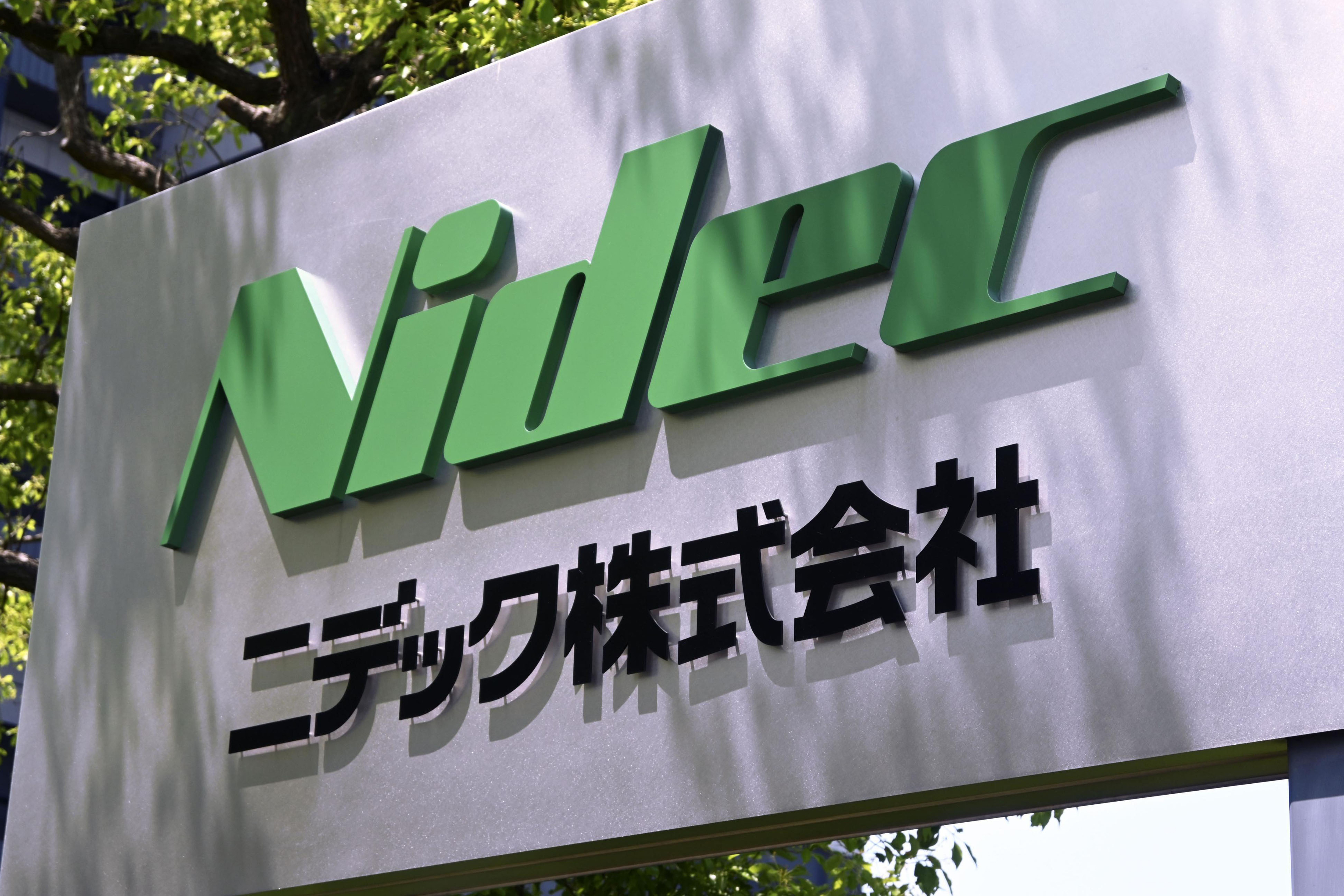 NIDEC Corporation green logo sign with Japanese text on outdoor wall