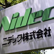 NIDEC Corporation green logo sign with Japanese text on outdoor wall