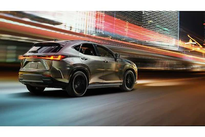 Luxury SUV driving through illuminated urban street at night with motion blur and city lights