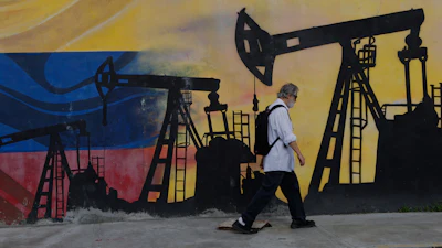 Street mural featuring oil pump silhouettes against Russian flag colors with pedestrian walking past