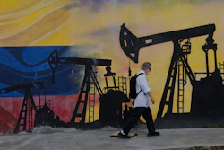 Street mural featuring oil pump silhouettes against Russian flag colors with pedestrian walking past