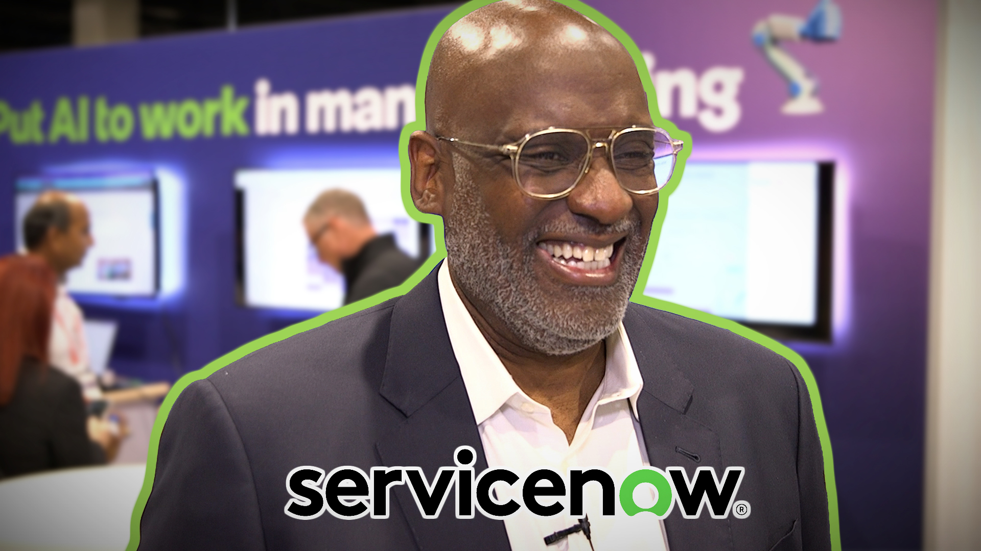 Professional man in glasses smiling at corporate event with ServiceNow branding