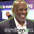 Professional man in glasses smiling at corporate event with ServiceNow branding
