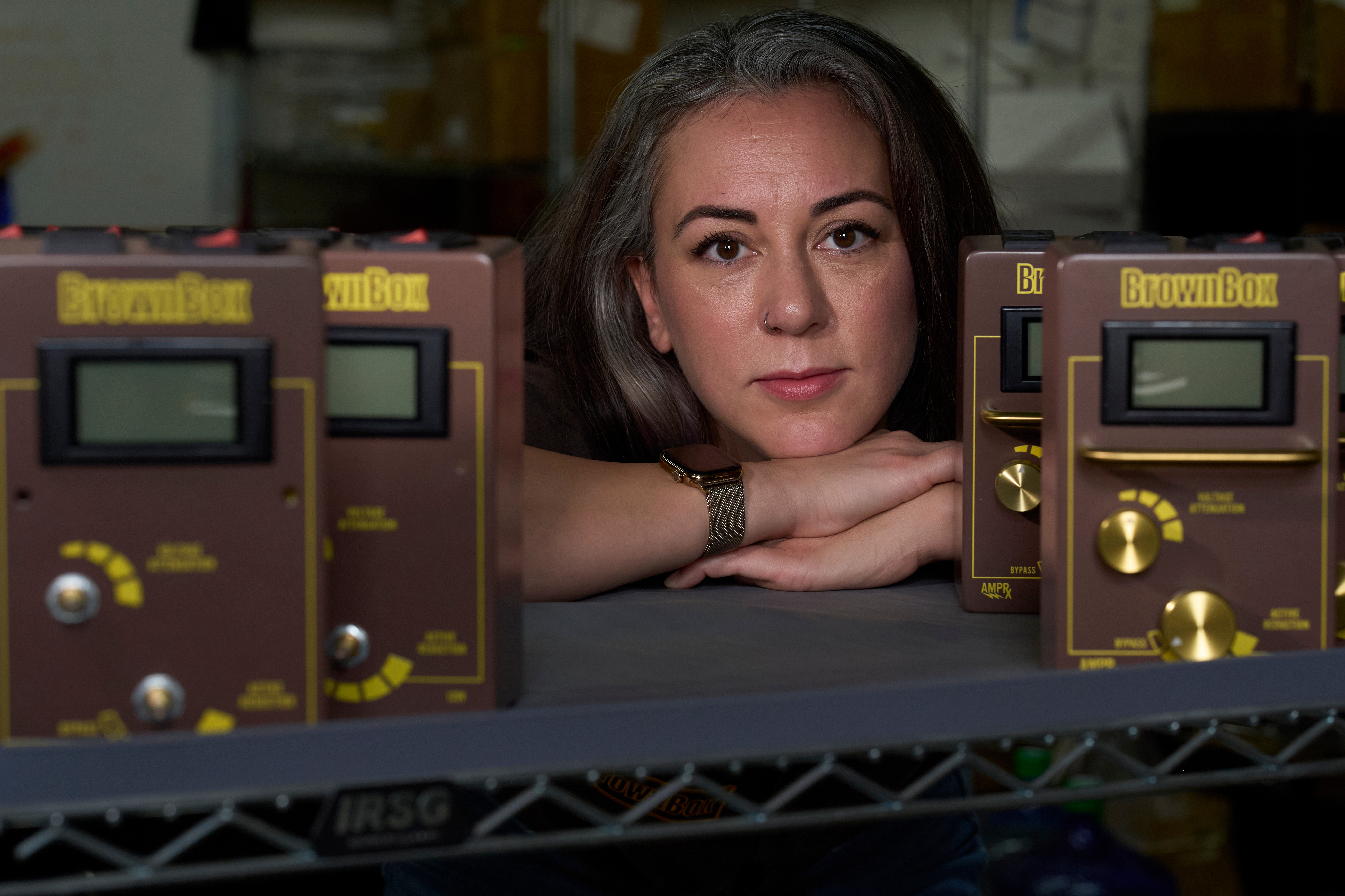 Woman posing with vintage Brownbear electronic measurement instruments in a studio setting