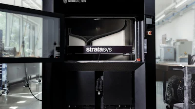 Stratasys F170 3D printer in industrial laboratory setting with white walls and equipment