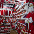 A vendor waits for customers near Santa costumes for sale at the Yiwu International Trade Market in Yiwu, eastern China's Zhejiang province on April 10, 2025.