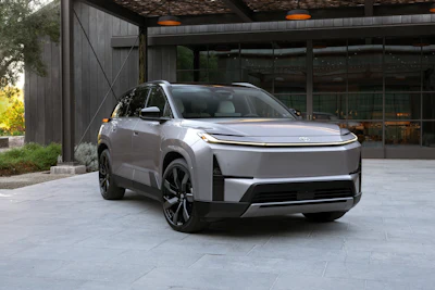 Silver Chevrolet Blazer EV parked in front of modern building with glass windows