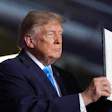 President Donald Trump displays a signed executive order at a campaign rally at the Pinnacle Bank Expo Center, Oct. 5, 2026, Grand Island, Neb.