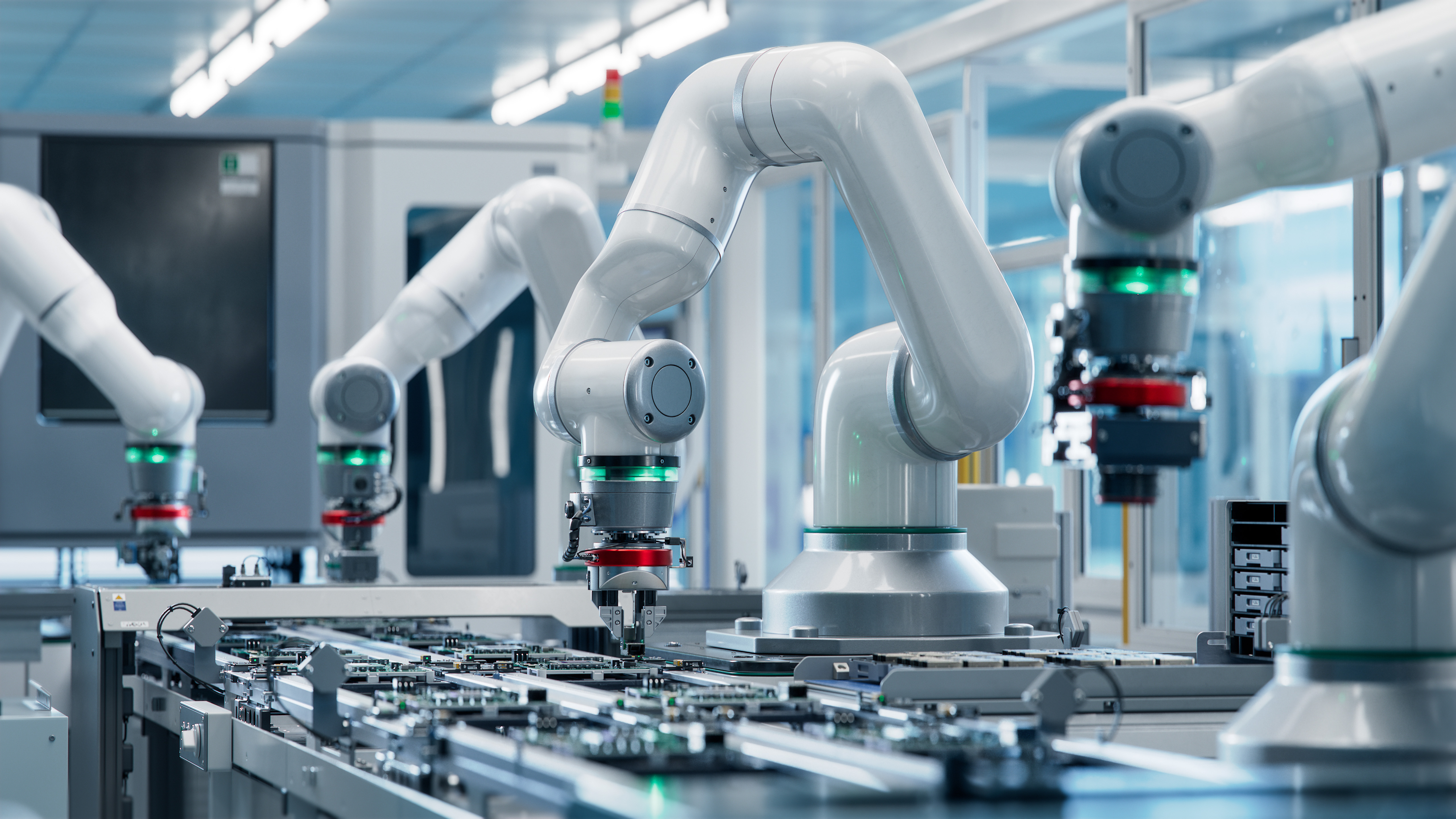 White collaborative robotic arms assembling electronic circuit boards in a modern manufacturing facility
