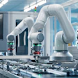 White collaborative robotic arms assembling electronic circuit boards in a modern manufacturing facility