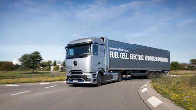 Mercedes-Benz fuel cell electric hydrogen-powered truck driving on highway with green landscape