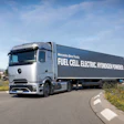 Mercedes-Benz fuel cell electric hydrogen-powered truck driving on highway with green landscape