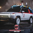 Rivian R1S electric SUV styled as Ghostbusters vehicle with roof-mounted equipment in nighttime urban setting