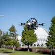 Police drone in flight over Florida Poly campus with trees and modern architecture in background